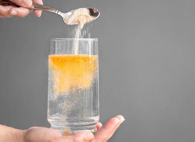 Orange fizzy powder and water glass with copy space. Healthy supplement.