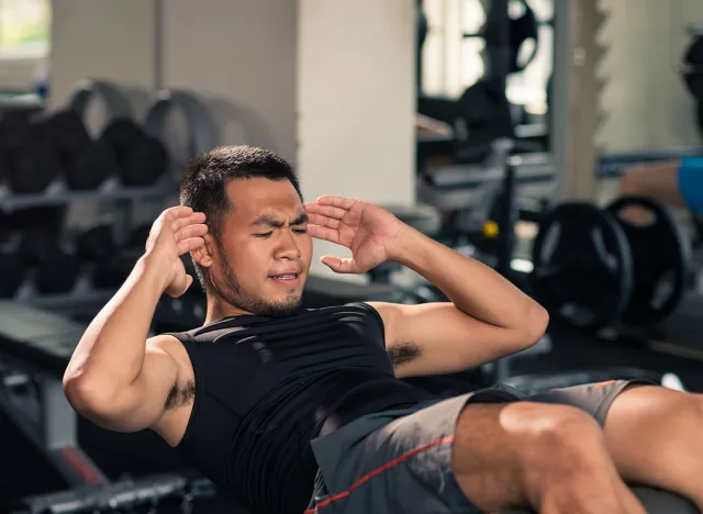 Athlete making effort to do last sit-up