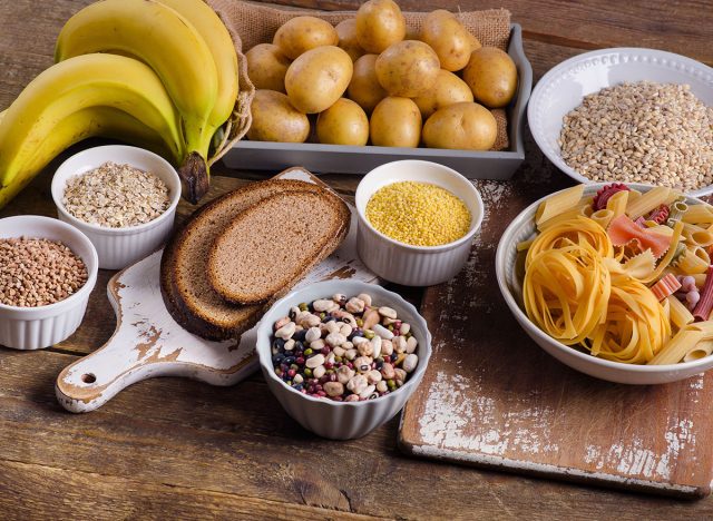 Foods high in carbohydrate on rustic wooden background. Top view