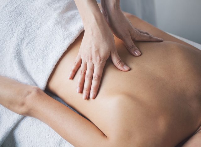 Young woman relaxing with hand massage at beauty spa.