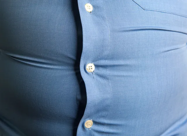 man with overweight. symbolic photo for beer belly, unsuccessful dieting and eating the wrong foods. Weight loss concept. Tight shirt.