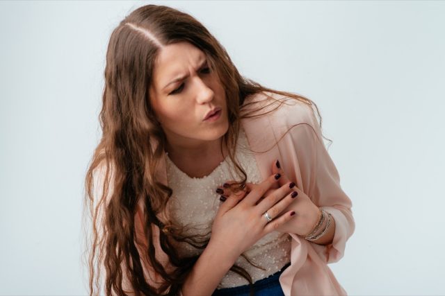 Woman holding her chest.