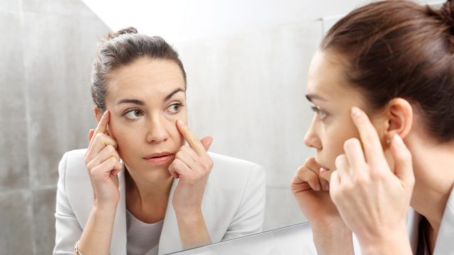 Woman looking at her reflection in the mirror.