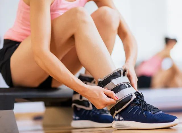 Woman at gym putting ankle weights