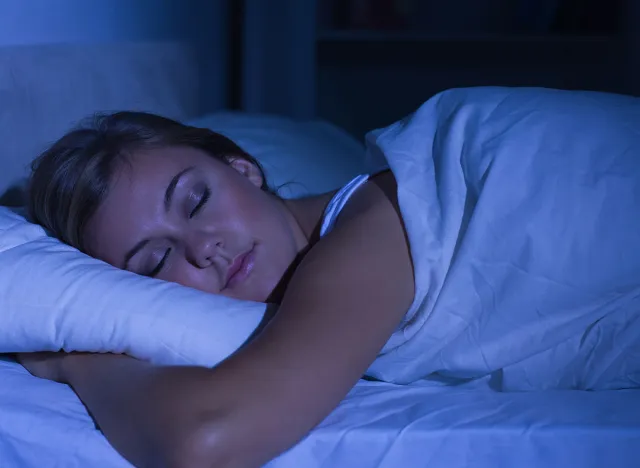 Serene woman sleeping at night in the bedroom