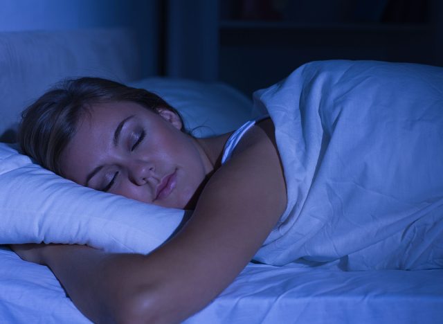 Serene woman sleeping at night in the bedroom