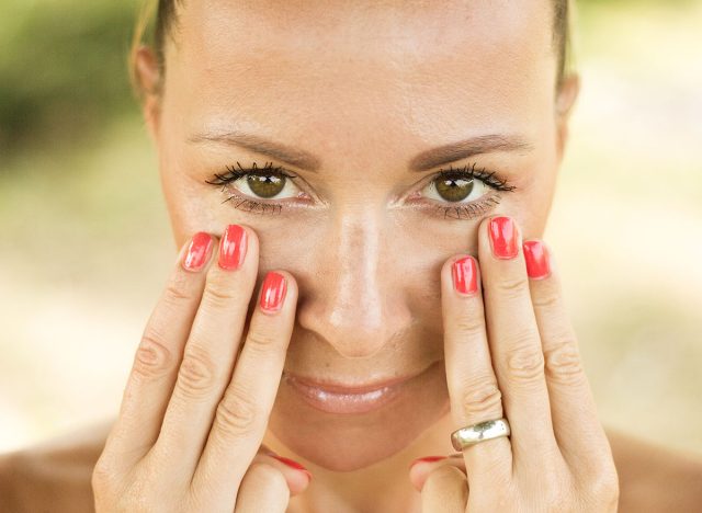 Facial gymnastics. The girl does massage and rejuvenating exercises for the face