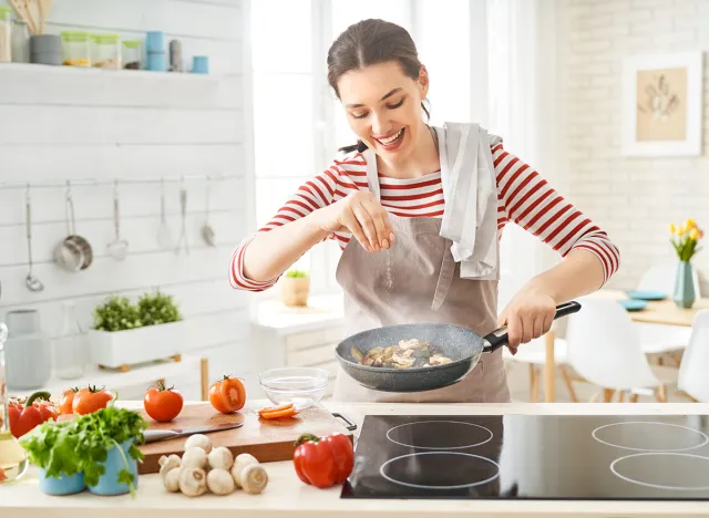 Healthy food at home. Happy woman is preparing the proper meal in the kitchen.