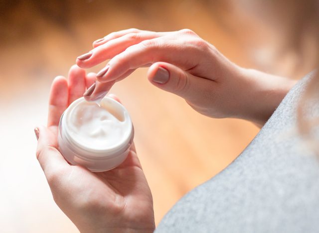 young woman uses body care cream