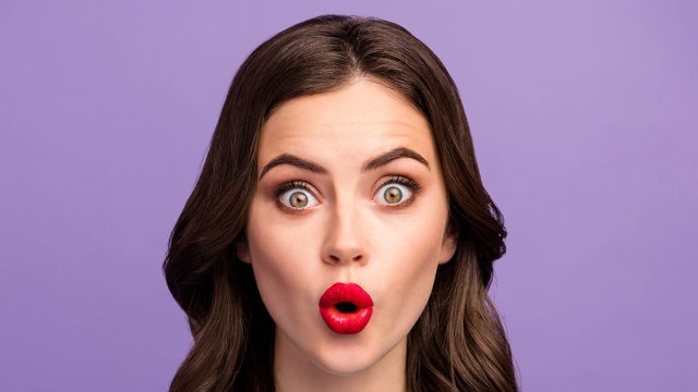 Closeup photo of beautiful pretty curly lady red lips o shape good mood listen amazing news open mouth wear casual blue knitted sweater isolated purple color background