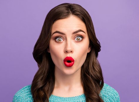 Closeup photo of beautiful pretty curly lady red lips o shape good mood listen amazing news open mouth wear casual blue knitted sweater isolated purple color background