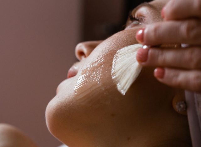 Close-up of a woman's face. The beautician makes a chemical peel. Skin care concept.