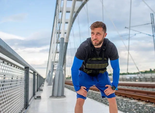 An athlete with a weight vest trains on the bridge