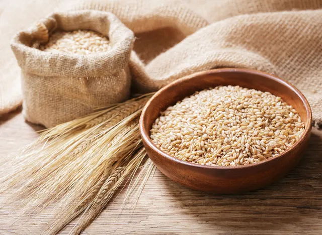 bowl of barley grains on a wooden table