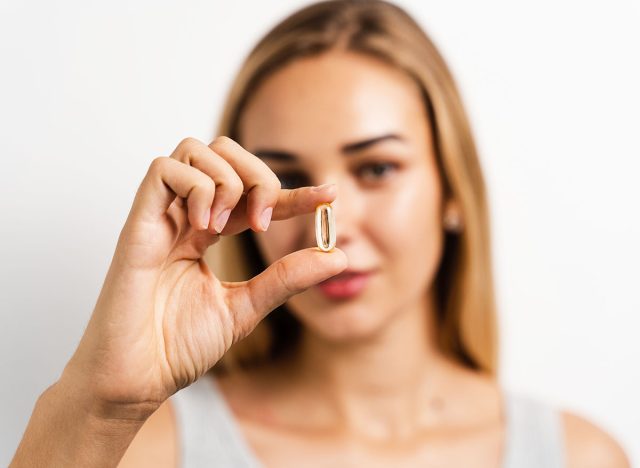 Girl with collagen supplement capsule close-up. Collagen pills to support skin health. BADS biologically active dietary supplements for healthcare