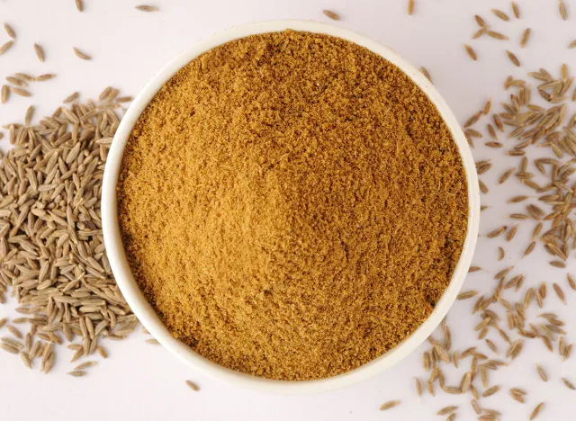 Ground cumin in a bowl and whole cumin