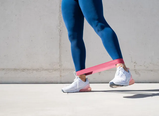 Woman exercising lateral leg lifts with resistance band