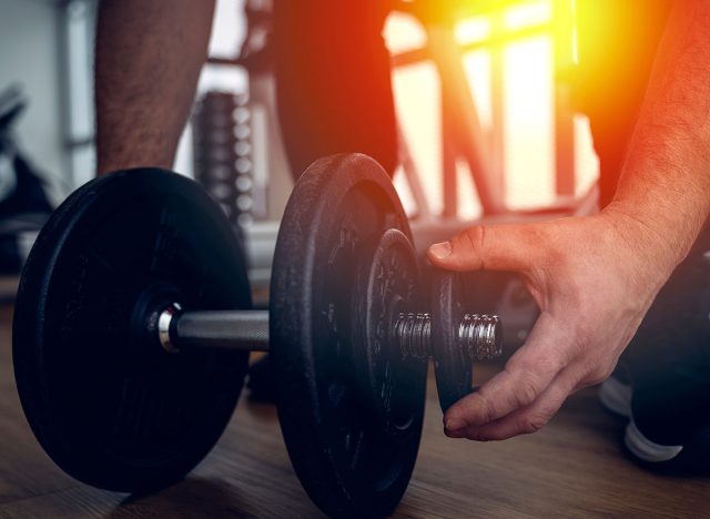 athlete in the gym with dumbbells. High quality photo