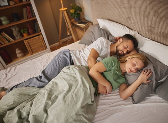 Couple sleeping embraced in bed