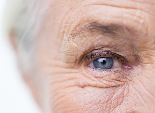 age, vision and old people concept - close up of senior woman face and eye