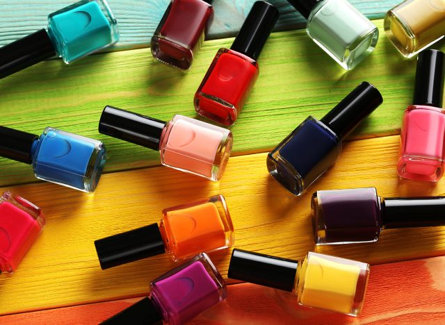 Bottles of nail polish on a colorful wooden table