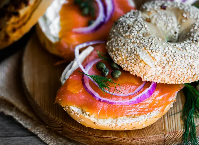 Bagels with cream cheese and smoked salmon on rustic wooden background