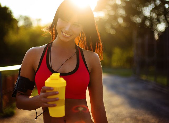 healthy fitness girl with protein shake. Smile sport woman in the sunny day