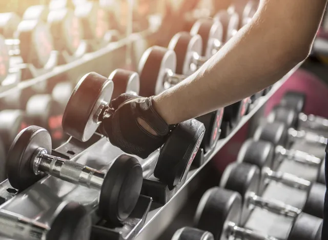 close up of man holding weight in gym