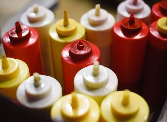 condiments of mustard, mayonnaise, ketchup and hot sauce on a hot dog cart