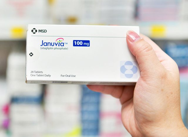 Bangkok,Thailand - May 30,2019 :Pharmacist holding Januvia 100mg. box medicine for diabetes mellitus (DM) or high blood sugar in pharmacy drugstore.