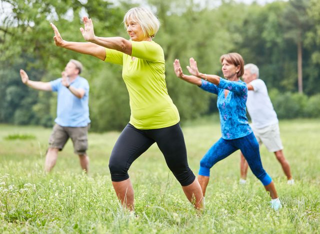 Seniors in the wellness class do Qi Gong or Tai Chi exercise for relaxation