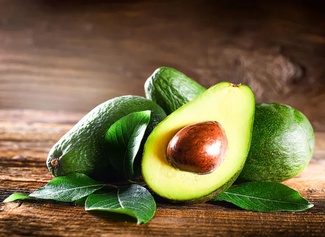 Avocado on rustic wooden table. Raw Fruits healthy green food concept.