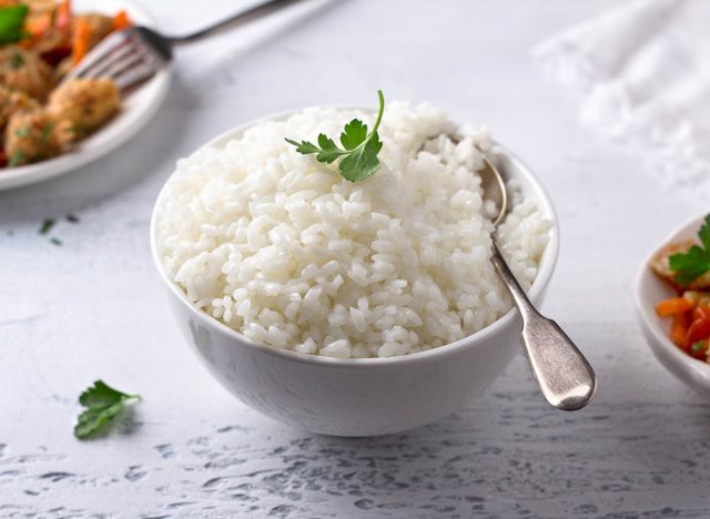 A bowl of cooked rice with a stew of soy meat and vegetables on a light gray background. vegan natural diet food. selective focus, horizontal