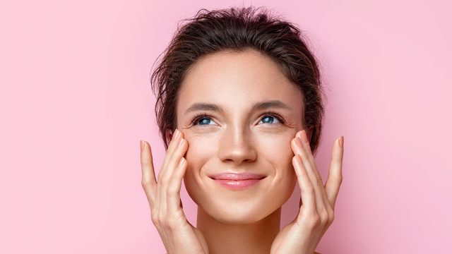 Beautiful woman with perfect skin on pink background. Beauty and skin care concept