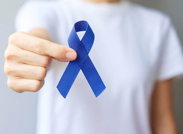 March Colorectal Cancer Awareness month, Woman holding dark Blue Ribbon for supporting people living and illness. Healthcare, hope and World cancer day concept