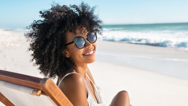 Summer,Beach,Portrait,Of,Happy,Young,Black,Woman,Relaxing,On,Wooden,Deck