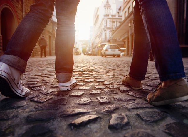 tourist couple walking on cobblestone street vacation in europe on holiday break