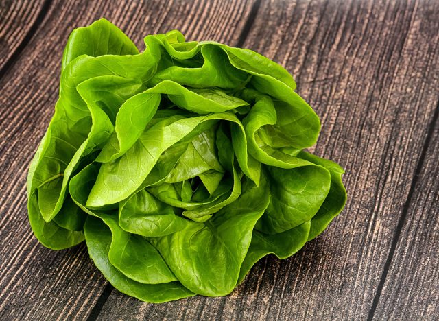 Butter lettuce salad green leaves over wooden background