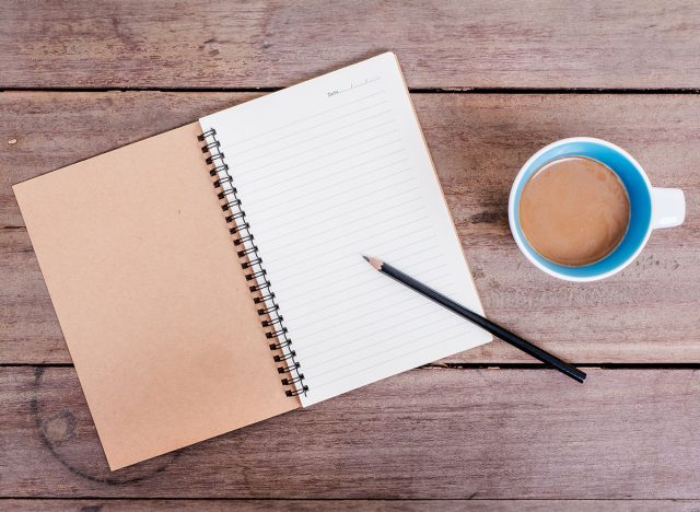 Cup of coffee, and note on old wooden table