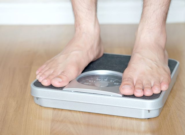 Legs of men standing on scales weight. Concept of health and weight loss.