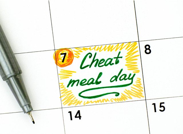 Reminder Cheat Meal Day in calendar with green pen. Close-up.