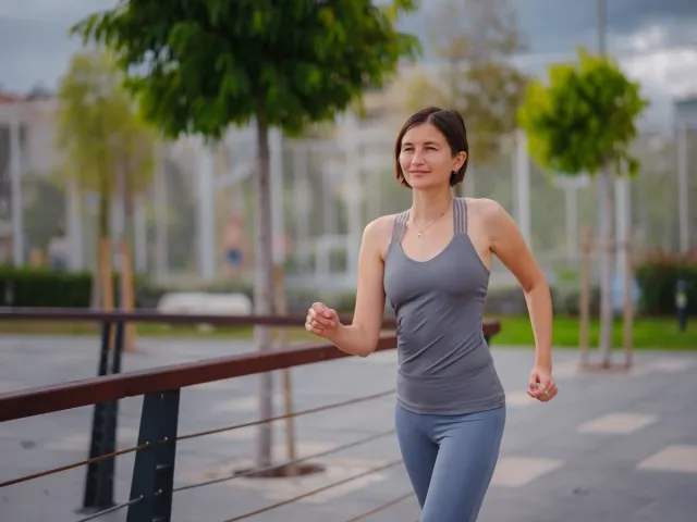 outdoor sports, workout and wellness concept. asian young strong, confident woman in sportive clothes in green park.