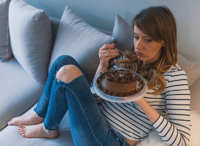 Depressed woman eats cake. Sad unhappy woman eating cake. Sad woman eating sweet cake. Close up of woman eating chocolate cake. food, junk-food, culinary, baking and holidays concept