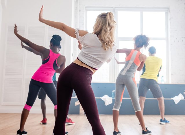 Back view of multiethnic zumba dancers performing movements in dance studio