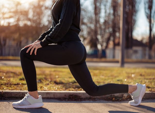 Woman doing walking lunges outdoors. Fitness, sport and healthy lifestyle concept.