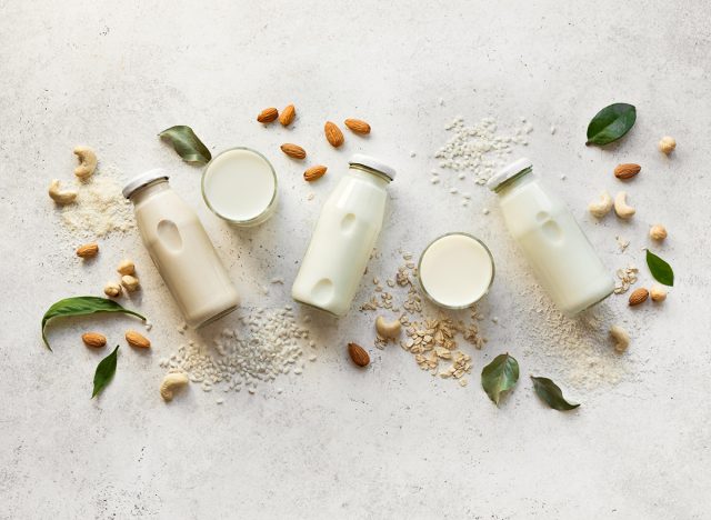 Vegan plant based milk and ingredients, top view, copy space. Various dairy free, lactose free nut and grains milk, substitute drink, healthy eating.