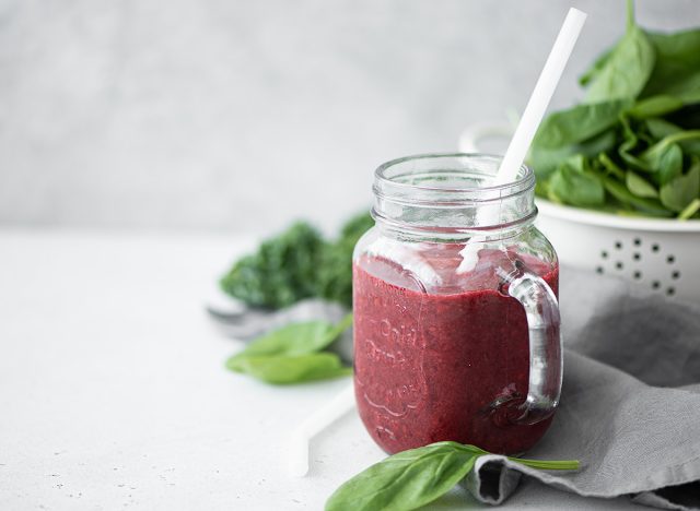 berry smoothie with spinach and chia seeds in a glass mug