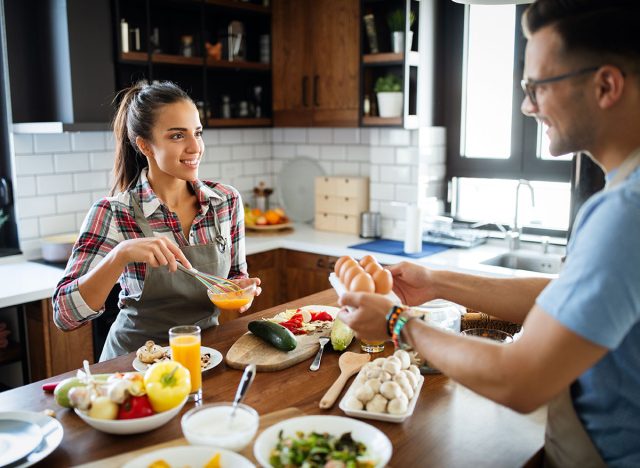 Beautiful young couple having fun in the kitchen while cooking.