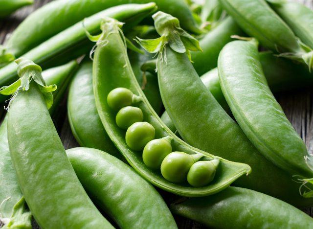 Snap peas placed on an old wooden board. Close-up, image of snap peas.