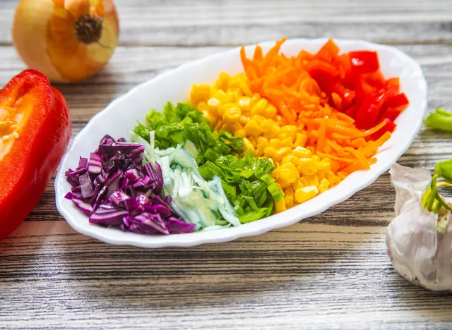 Delicious vegetable salad on a white plate, vegetables are in the colors of the rainbow.